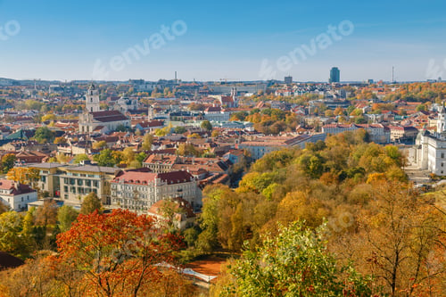 Preview: Stunning autumn view of Vilnius showcasing colorful trees and historic architecture across the city