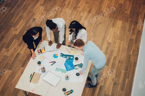 Preview: High angle shot of a multiracial business team having a meeting in office