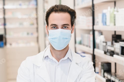 Preview: Pandemic, lockdown. Druggist in protective face mask against Covid19 in pharmacy drugstore