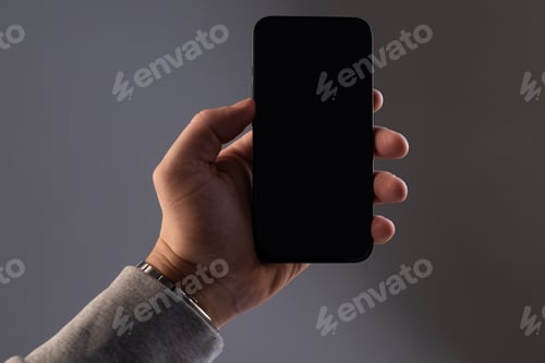 Preview: black rectangular modern smartphone he in a male hand on a gray isolated background, Concept mockup