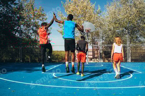 Preview: Unrecognizable teenager friends having fun playing basketball