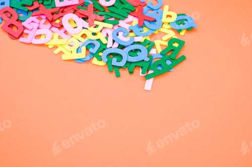 Preview: Top view closeup of the letters of the English alphabet isolated on an orange background