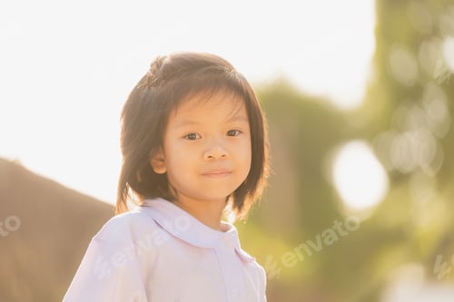Preview: Portrait of Smiling Asian child Girl portrait outdoors in a park during summer.