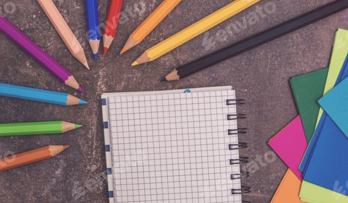 Preview: Colorful Pencils and Notebook on Grey Textured Surface