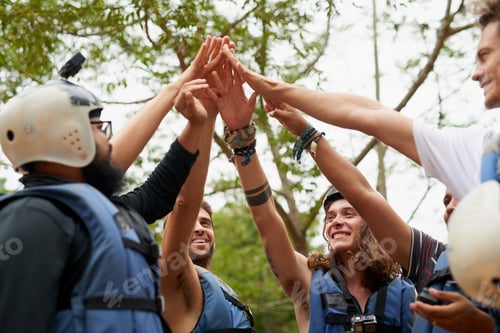 Enthusiastic Team Raising Hands Together Outdoors