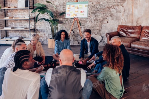 Preview: Business people sitting in circle having a brainstorming meeting