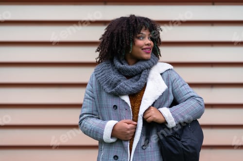 Preview: Portrait of black ethnic girl a gray wall in the university, with a schoolgirl on the back of the