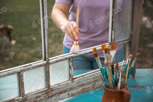 Preview: Painting a wooden vintage window outdoors, an eco-friendly re-use business.