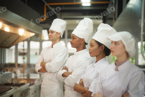 Preview: Culinary team of chefs stands together in a modern kitchen during a cooking session