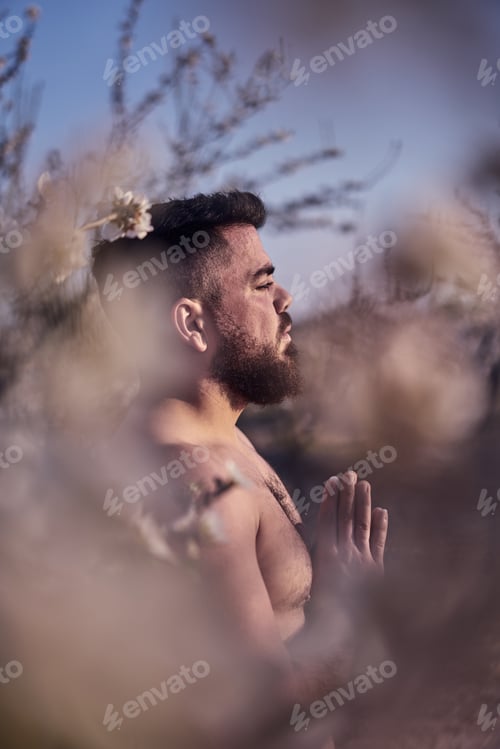Preview: Shirtless man meditating in spring garden