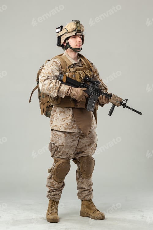 Preview: Soldier stands in uniform with weapon in studio setting for training or display purposes