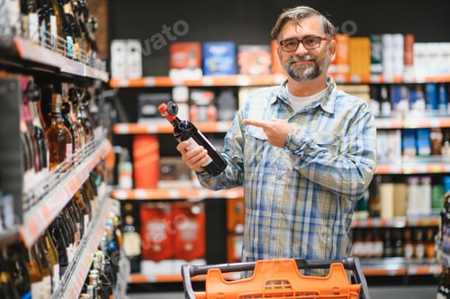 Preview: Man in a supermarket choosing a wine