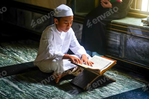 Preview: Young boy reads religious text in a quiet mosque setting during the day