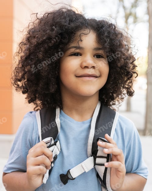 Preview: curly haired boy back to school, preschool, grabbing his backpack happy smiling