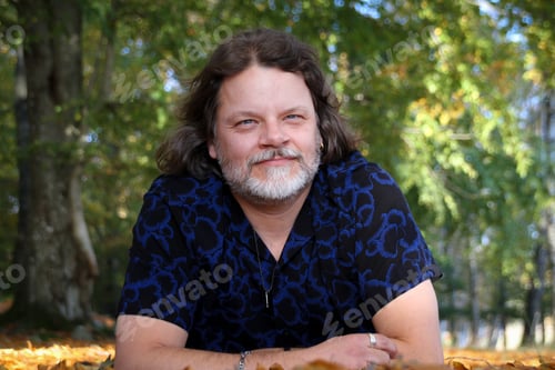 Preview: Middleaged confident man, male portrait in the park in autumn fall beech