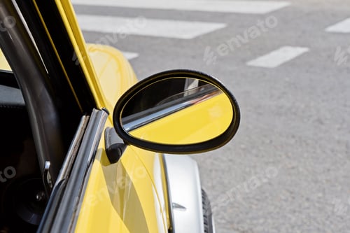 Preview: Yellow vintage car side mirror closeup at crosswalk