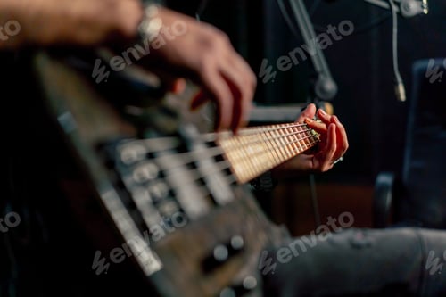 Preview: close up shot the equipment of a recording room handsome man with a beard and tattoos plays an