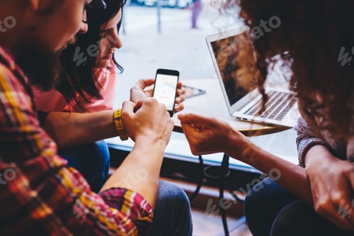 Preview: Crop of friends using smartphone together