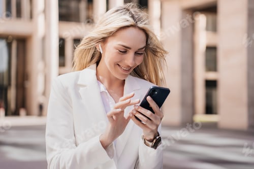 Preview: Excited young blonde businesswoman woman making video call by phone, earphones, with happy face