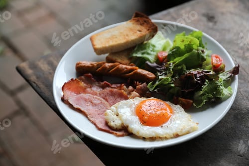 Preview: English Breakfast Fried Egg, Ham,Sausage, Bacon,Salad And Toast On Wood Background In Mystic Light