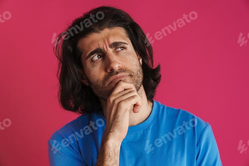 Preview: Puzzled brunette man in t-shirt think and looking upward