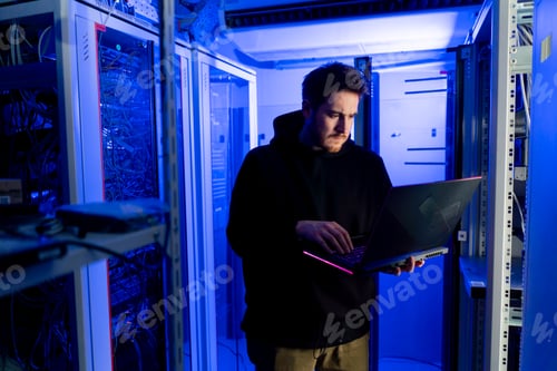 Preview: focused hacker in data center hacking software system vulnerable cyber security server room