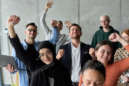 Preview: A diverse team of business professionals ecstatically celebrating their success in a modern office