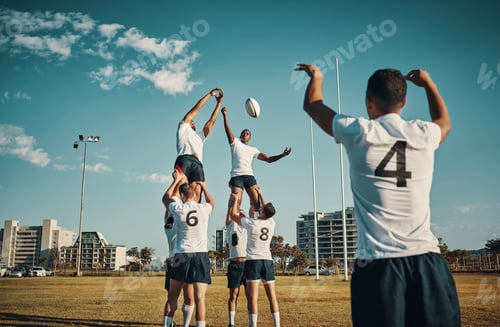 Preview: Cropped shot of two handsome young rugby players catching the ball during a lineout on the field