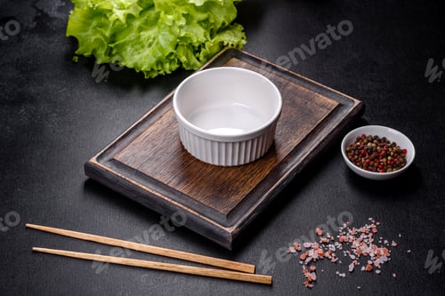 Preview: An empty white bowl and sticks on a wooden cutting board