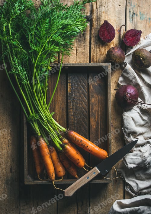 Preview: Garden carrots and beetroots in wooden tray over rustic background