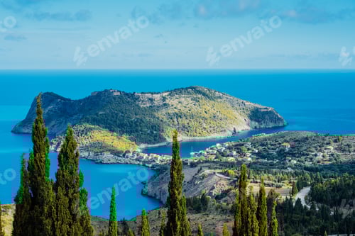 Preview: Above view to Assos village and beautiful blue sea. Cypress trees stands out in foreground