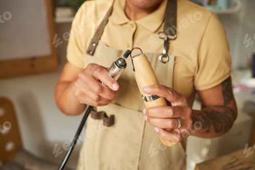 Preview: Tattooed female jeweler using tools