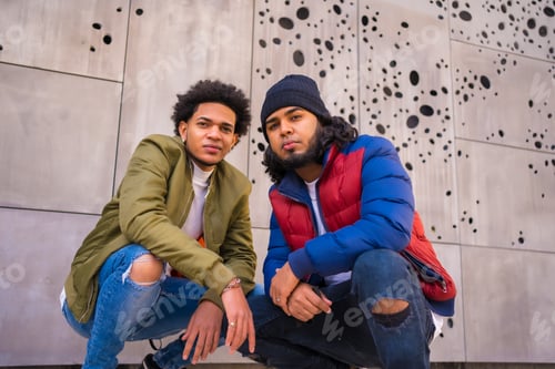Preview: Urban style, portrait of two Latino black friends having fun in the street. Afro hair boy, brunette