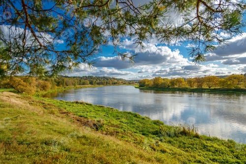 Preview: Vibrant autumn landscape showing a wide river with the riverbanks