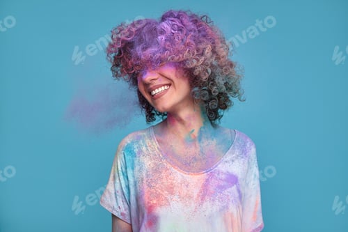 Preview: Carefree woman in Holi powder in studio