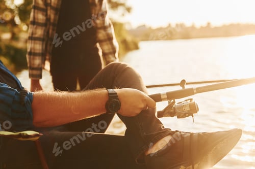 Preview: Sunny weather. Father and son on fishing together outdoors at summertime