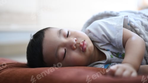 Preview: Close up view of baby boy sleeping on comfortable bed at home.