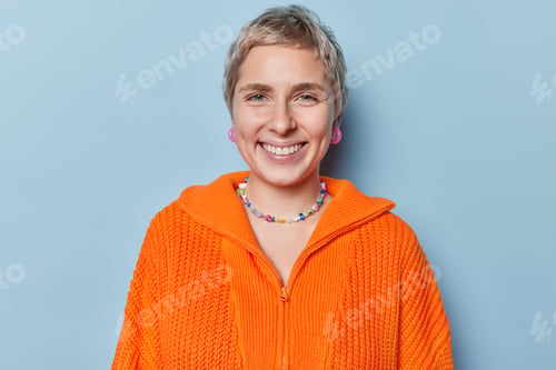 Preview: Portrait of cheerful European female model with short hair smiles toothily expresses positive