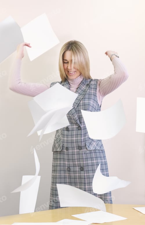 Preview: business woman throwing paper into he air and smiling. end of the day, difficult project done.
