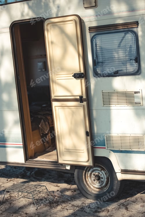 Preview: close up of travel trailer with open door in camp