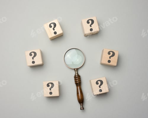 Preview: Wooden magnifier and cubes with question marks on gray background