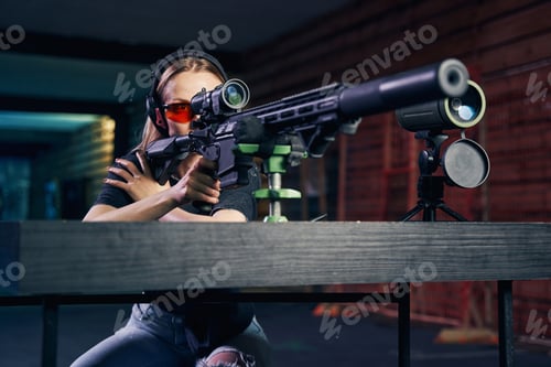 Preview: Woman in headphones and safety glasses firing a weapon