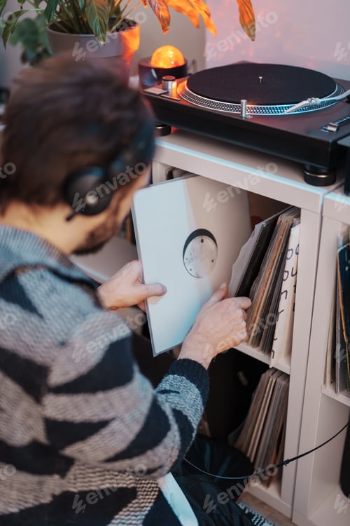 Preview: Man searching through vinyl records at home music corner
