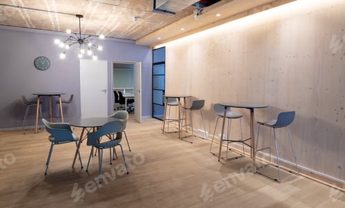 Preview: Empty chairs arranged around tables on hardwood floor in illuminated office