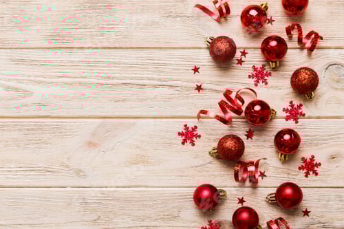 Preview: Christmas Baubles, Confetti and Streamers on a Wooden Surface