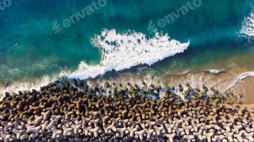 Preview: Overhead aerial shot of a wavy blue sea against the rocks