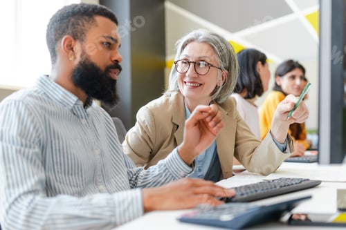 Preview: Coworkers collaborating and brainstorming on computer in office