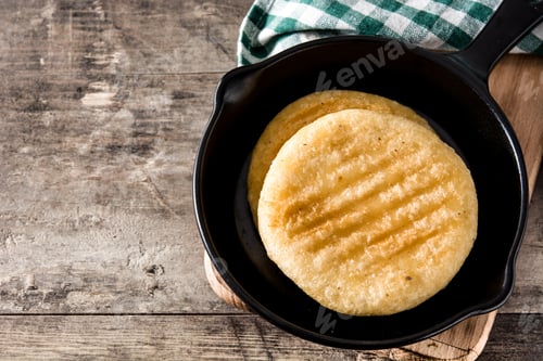 Preview: Delicious arepas in cast iron skillet resting on rustic wooden table