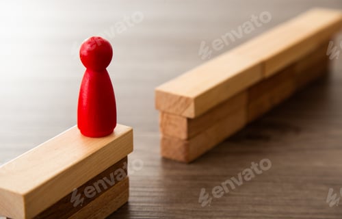 Preview: Red pawn standing on wooden blocks facing a gap and a wall of blocks symbolizing challenge