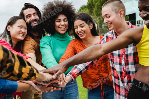 Preview: Young multiethnic group of people stacking hands together outdoor - Teamwork diversity concept